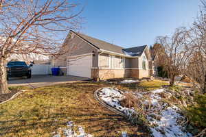 View of side of property with a garage and a lawn