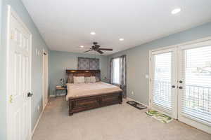 Carpeted bedroom featuring access to outside, ceiling fan, and a textured ceiling