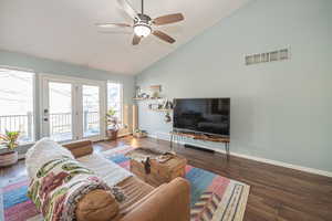 Living room featuring dark hardwood / wood-style flooring, high vaulted ceiling, and ceiling fan