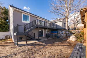 Rear view of property featuring a patio area, cooling unit, a hot tub, and a deck