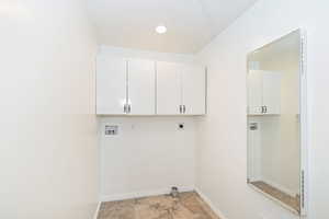 Laundry room with washer hookup, electric dryer hookup, cabinet space, and baseboards