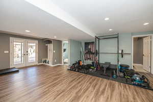 Exercise room with french doors, wood-type flooring, and a textured ceiling