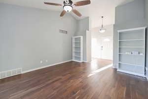 Unfurnished living room featuring high vaulted ceiling, a ceiling fan, wood finished floors, and baseboards