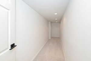 Hall with light carpet, recessed lighting, and baseboards