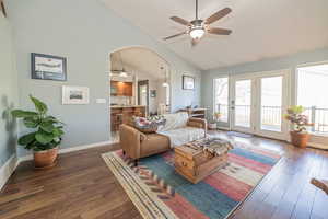 Living room with ceiling fan, sink, dark hardwood / wood-style floors, and vaulted ceiling