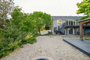 Rear view of house with stairs, a wooden deck, fence, and a patio area