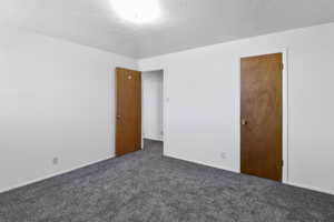 Unfurnished room featuring dark carpet