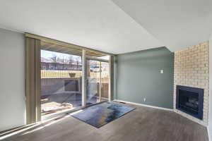 Unfurnished living room featuring floor to ceiling windows, hardwood / wood-style floors, and a fireplace