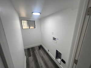 Washroom with hookup for a washing machine and dark hardwood / wood-style floors