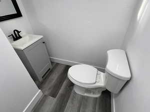 Bathroom with toilet, vanity, and hardwood / wood-style flooring