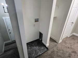 Clothes washing area featuring washer hookup and dark colored carpet