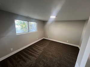 Unfurnished room with dark colored carpet