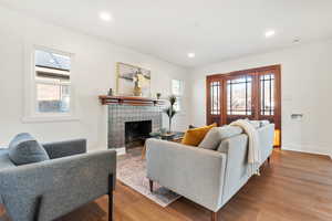 Living room featuring light hardwood / wood-style floors and a brick fireplace