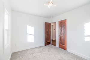 Unfurnished bedroom with light colored carpet