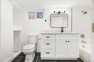 Full bathroom featuring shower / tub combination, tile patterned flooring, vanity, and toilet