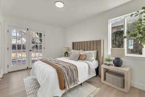 Bedroom featuring french doors, access to outside, and light hardwood / wood-style flooring