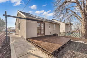 Rear view of house with cooling unit and a deck