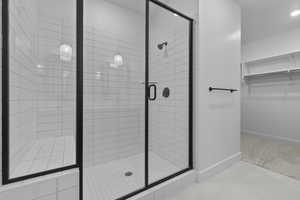 Bathroom featuring tile patterned flooring and a shower with shower door