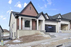 View of front of house featuring a garage, central air condition unit, and covered porch