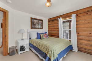 Bedroom with carpet floors and rustic walls