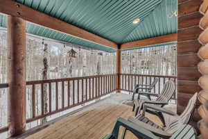 Snow covered deck with covered porch