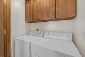 Laundry room featuring cabinets and separate washer and dryer