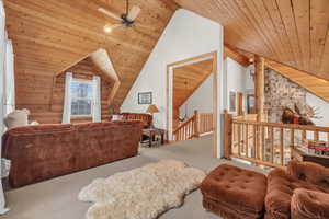 Living room with ceiling fan, carpet floors, wooden ceiling, and lofted ceiling