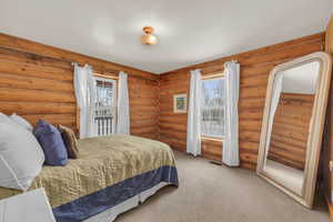 Bedroom featuring carpet floors and rustic walls