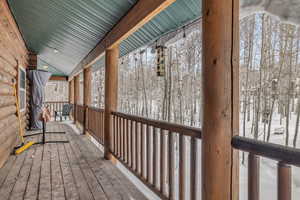 Snow covered deck featuring a porch