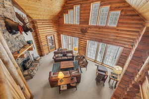 Living room with rustic walls, wood ceiling, lofted ceiling, and a wood stove