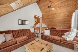 Living room with carpet, ceiling fan, wooden ceiling, and high vaulted ceiling