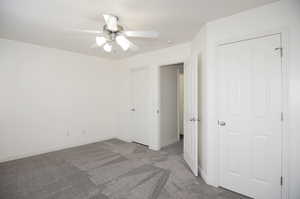 Unfurnished bedroom featuring ceiling fan and light colored carpet