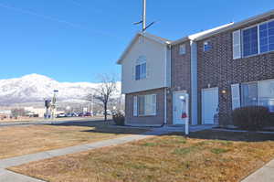 View of front of house featuring a mountain view and a front lawn