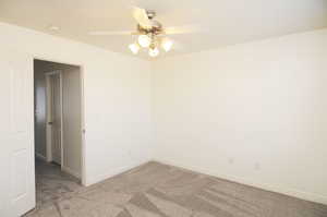 Carpeted spare room with ceiling fan