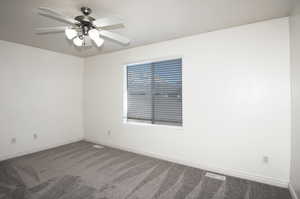 Carpeted empty room with ceiling fan