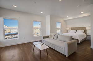 Bedroom with multiple windows and dark wood-type flooring