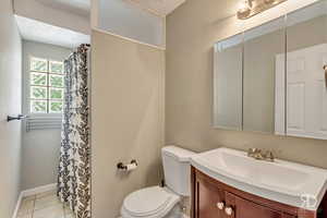 Bathroom with tile patterned flooring, vanity, a textured ceiling, and toilet