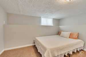 Bedroom featuring carpet flooring and a textured ceiling