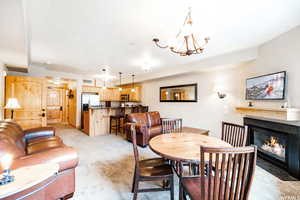 Carpeted dining area featuring a notable chandelier