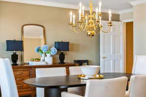 Dining area featuring ornamental molding and a chandelier