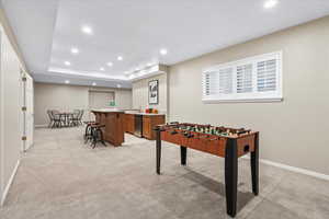 Game room featuring bar area and light colored carpet