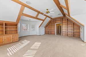 Bonus room featuring light carpet, vaulted ceiling, built in features, and ceiling fan