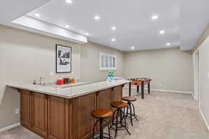 Bar featuring light carpet and light stone counters