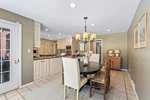 Tiled dining area with a chandelier