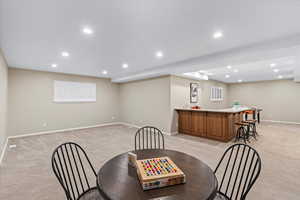 Carpeted dining room featuring bar