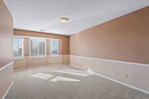 Carpeted empty room with a textured ceiling