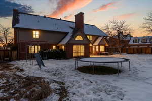 Snow covered house featuring a trampoline