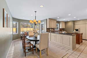 Tiled dining space with a chandelier and sink