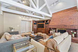 Living room with high vaulted ceiling and a brick fireplace