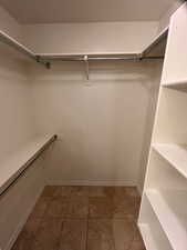 Walk in closet featuring dark tile patterned floors